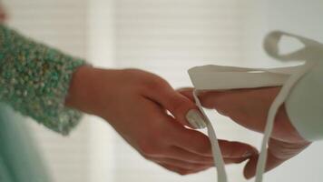 Close-up of hands tying a white ribbon, symbolizing unity and partnership. video