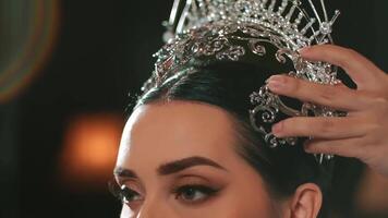 elegante mulher ser coroado com uma tiara, foco em a tiara e mãos. video