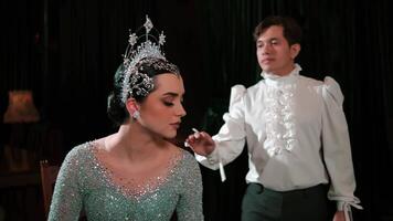 Man whispering to an elegant woman in a sparkling tiara and costume, depicting secrecy or gossip in a vintage setting. video