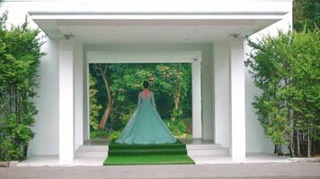 Modern white pavilion with a green roof, set against a lush forest backdrop, offering a serene and minimalist architectural design. video