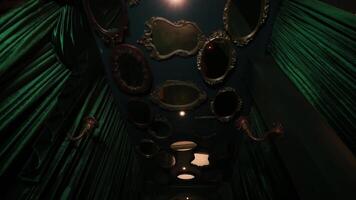 Vintage mirrors on a teal wall with dramatic lighting, creating an eerie and mysterious atmosphere. video