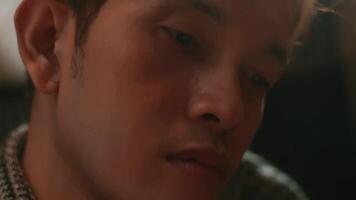 Close-up of a young man's face in dim lighting, highlighting his contemplative expression. video