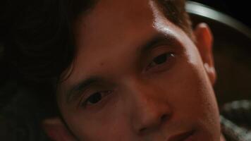 Close-up of a young man's face with a contemplative expression, shallow depth of field. video