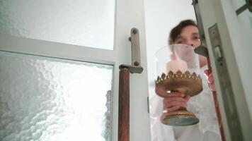 Blurred figure holding a chalice and crucifix, suggesting a religious or spiritual theme, with soft lighting and a frosted glass background. video