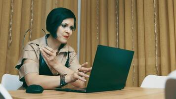 Woman completes work on laptop. The girl closes the laptop, takes off her glasses and thinks dreamily. End of working day. video