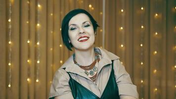 Portrait of a beautiful successful woman smiling. Caucasian business woman smiling, talking and looking at the camera against a background of yellow flashing lights. video