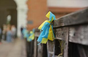 Ribbons in the colors of the national flag of Ukraine are tied to the handrail photo