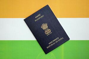 Blue Indian passport on national flag background close up photo