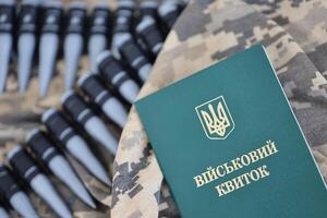 Ukrainian military ID on fabric with texture of pixeled camouflage. Cloth with camo pattern in grey, brown and green pixel shapes with Ukrainian army personal token photo