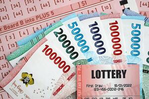 rojo lotería boleto mentiras en rosado juego hojas con indonesio rupia dinero cuentas foto