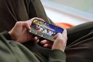 Fate Grand Order mobile iOS game on iPhone 15 smartphone screen in male hands during mobile gameplay photo