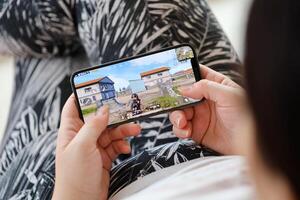 PUBG PlayerUnknowns Battlegrounds mobile iOS game on iPhone 15 smartphone screen in female hands during mobile gameplay photo
