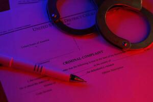 District Court Criminal complaint court papers with handcuffs and blue pen on table photo