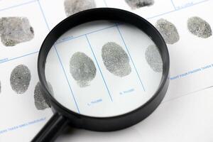 Fingerprints card police form on A4 tablet lies on office table with pen and magnifying glass photo