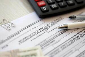 Information on amount of income or loss from non-agricultural economic activity, PIT-B form on accountant table with pen and polish zloty money bills photo