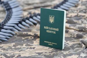 Ukrainian military ID on fabric with texture of pixeled camouflage. Cloth with camo pattern in grey, brown and green pixel shapes with Ukrainian army personal token photo