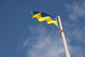 Ukraine flag large national symbol fluttering in blue sky. Large yellow blue Ukrainian state flag, Dnipro city, Independence Constitution Day photo