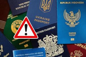 Many various passports of citizens of different countries and regions of the world and alert sign photo