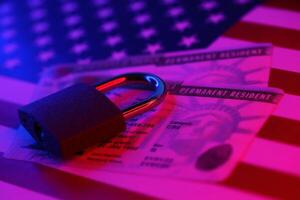 Permanent resident green card for US DV-lottery with small padlock on US flag photo