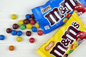 KHARKIV, UKRAINE - JANUARY 2, 2021 M and Ms colorful button shaped chocolate candies. Multi colored chocolates each of which has the letter m printed in lower case in white photo