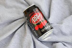 KYIV, UKRAINE - 4 MAY, 2023 Dr Pepper cherry drink black cans photo