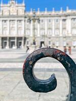 Madrid's Royal Palace on the background from the forged part of fence outside photo