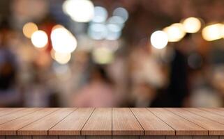 Empty wooden table top with lights bokeh on blur restaurant background photo