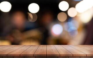 Empty wooden table top with lights bokeh on blur restaurant background photo