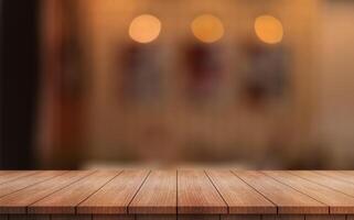 Empty wooden table top with lights bokeh on blur restaurant background photo