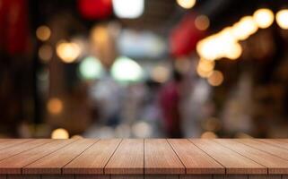 Empty wooden table top with lights bokeh on blur restaurant background photo