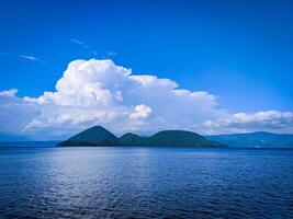 tropical isla en el mar con azul cielo y blanco nubes foto