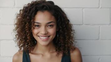 AI generated Close up studio shot of beautiful young mixed race woman model with curly dark hair looking at camera with charming cute smile while posing against white blank copy space wall photo