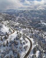 AI generated Aerial view of winding road in mountains with snow photo