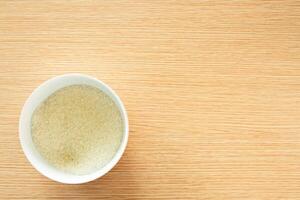 a small bowl filled with granulated sugar on a wooden table photo