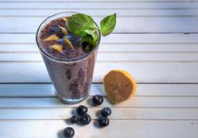 Top view of blueberry smoothies on natural white wood surface photo