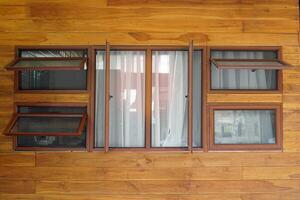 Wooden framed glass window. There are both double windows designed to be in the middle. The left and right sides are Awning Windows, 2 on each side, arranged in top and bottom positions. photo