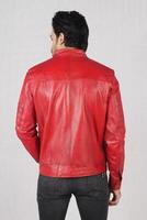 handsome pakistani young man in red biker leather jacket on white background, closeup, full height, smiling poses photo