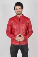 handsome pakistani young man in red biker leather jacket on white background, closeup, full height, smiling poses photo