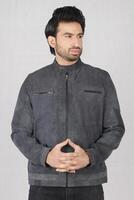 handsome young man wearing a leather jacket and posing in the studio. photo