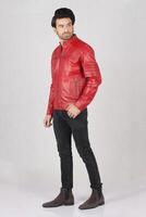 handsome pakistani young man in red biker leather jacket on white background, closeup, full height, smiling poses photo