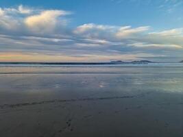 Sunset at Playa de Famara, Lanzarote, paints the sky with vibrant hues, casting a mesmerizing glow over the horizon. Breathtaking sight that captures the essence of tranquility and natural beauty. photo