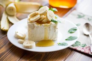 Portion of homemade milk curd with banana slices and honey photo