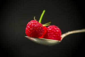 Sweet raspberry fruit isolated on black background photo