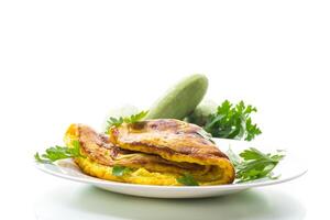Fried omelette with zucchini,in a plate on a white background. photo
