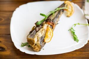 Baked fish with seasonings and spices in a plate photo