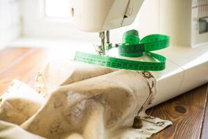 de coser máquina con tela y hilos para de coser, de cerca. el trabajando proceso foto