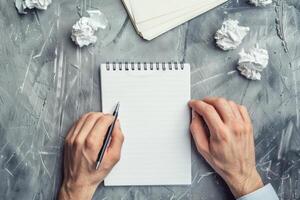 AI generated Man brainstorming ideas with a notepad and pen. Hand with pen writing on notebook. Generative AI photo