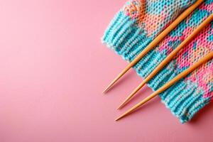 AI generated Knitting needles and unfinished colorful knitted sweater on pink background. Generative AI photo