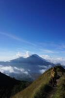 Peak Paradise, Asian Model on Mount Batur Summit with Ocean of Clouds under Azure Sky photo