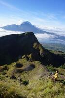 Asian Adventure, Man Model on Mountain Summit, Carrying Hiking Gear under Blue Sky above Ocean of Clouds photo